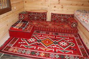 two beds in a room with a rug on the floor at Kapuzbaşı Şelaleleri Uçar pansiyon in Büyükçakır