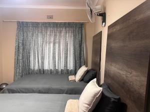 a bedroom with a bed and a window at Amatis House in Mokopane