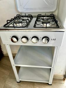 a stove top oven sitting on a stand in a kitchen at NT Dreamhouse Cameroon in Zalom