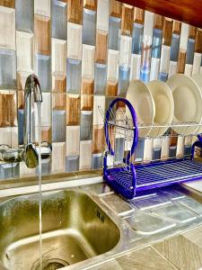a kitchen sink with a dish drying rack with plates at NT Dreamhouse Cameroon in Zalom