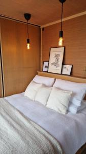 a bedroom with a white bed with three pillows at Nyth - Nest Llangollen in Llangollen