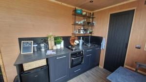 a kitchen with a black counter top in a room at Nyth - Nest Llangollen in Llangollen