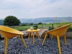 two chairs and a yellow table and a table at Nyth - Nest Llangollen in Llangollen