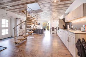 a large kitchen with wooden floors and a spiral staircase at Haus Sonnengelb in Taarstedt