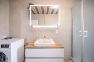 a bathroom with a sink and a washing machine at Haus Sonnengelb in Taarstedt