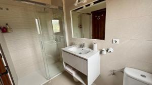 a bathroom with a sink and a shower with a mirror at Posada El Bosque in Mieses +36 photos