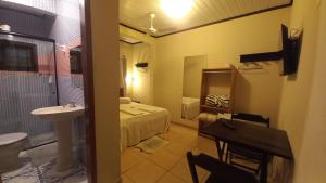 a bathroom with a bed and a sink and a toilet at Pousada Girar do Sol in Nova Friburgo +18 photos