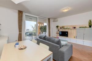 a living room with a couch and a table at MGH- Lake Serenity Apartment in Padenghe sul Garda