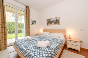 a bedroom with a bed with two towels on it at MGH- Lake Serenity Apartment in Padenghe sul Garda