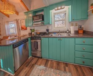 a kitchen with green cabinets and a sink at Sophie Cabin National Forest Tiny Cabin in Chattanooga