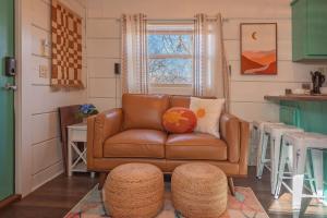 a living room with a brown leather couch and a stool at Sophie Cabin National Forest Tiny Cabin in Chattanooga +28 photos