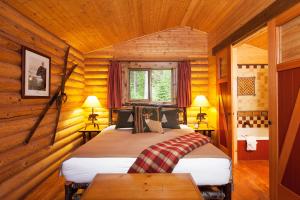 a bedroom with two beds in a log cabin at Cathedral Mountain Lodge in Field
