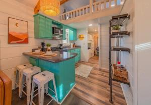 a kitchen with green cabinets and stools in a tiny house at Sophie Cabin National Forest Tiny Cabin in Chattanooga