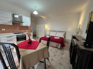 a room with a bed and a table and a kitchen at Casa Latiini 1-2 in Pontinia