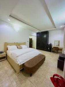 a large bedroom with a large bed and a desk at Bold 3 Bedroom Apartments in Abuja