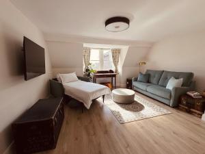 a living room with a couch and a bed and a tv at Courtyard Apartament in Ballymore