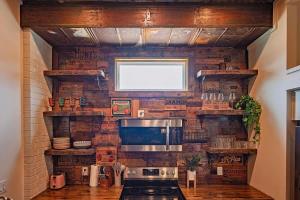 a kitchen with a brick wall with a stove at The Frothy Flat- A Bunny Slippers Optional Destination in Chattanooga
