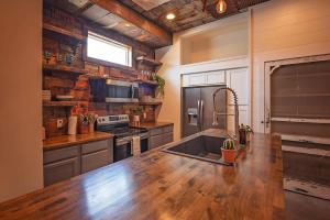 a kitchen with a wooden counter top with a sink at The Frothy Flat- A Bunny Slippers Optional Destination in Chattanooga