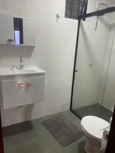 a bathroom with a sink and a shower and a toilet at Residencial Mandi in Guaíra +16 photos
