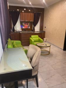 ein Wohnzimmer mit grünen Stühlen und einem Tisch in der Unterkunft Providha Hotel & Suites in Ikeja
