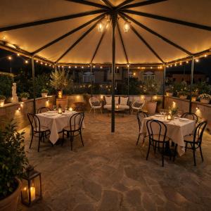 a patio with tables and chairs under an umbrella at Hotel Bottaccio in Frascati