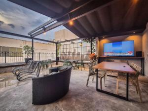 a patio with a table and chairs and a tv at Ceci House - Santa Cecília in São Paulo
