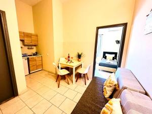 a small living room with a table and a kitchen at Sidari Vibes Aparthotel in Sidari
