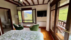 a bedroom with a bed and two green chairs at Posada El Bosque in Mieses