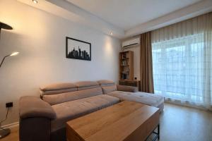 a living room with a couch and a large window at Salvatore Apartment #BucharestAirport in Ştefăneştii de Sus