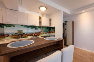 a kitchen with a counter with a sink and white cabinets at Salvatore Apartment #BucharestAirport in Ştefăneştii de Sus +2 photos