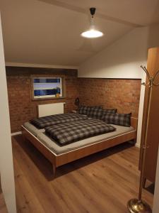 ein Bett in einem Zimmer mit einer Backsteinwand in der Unterkunft Auszeitbude Mudau, FeWo auf 48 m2 in Mudau