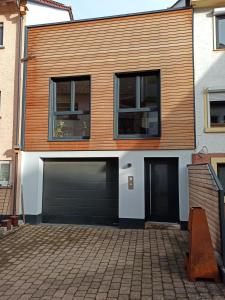 ein Haus mit zwei Garagentoren und zwei Fenstern in der Unterkunft Auszeitbude Mudau, FeWo auf 48 m2 in Mudau