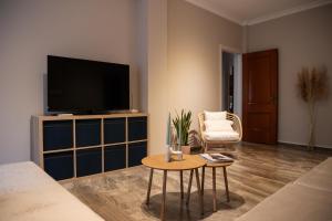 a living room with a television and a table at Central Boutique Apartment Gythio in Gythio