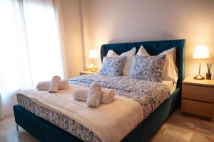a bedroom with a blue bed with pillows at Central Boutique Apartment Gythio in Gythio