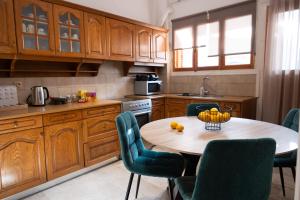 a kitchen with a wooden table and chairs and a table with fruit on it at Central Boutique Apartment Gythio in Gythio