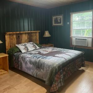 a bedroom with a bed with blue walls at Cabin #1 on Meramec River in Steelville