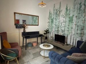 a living room with a blue couch and a piano at La Casa de María Castaña in Seville
