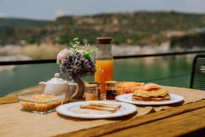 Ein Tisch mit zwei Tellern Essen und einer Flasche Saft in der Unterkunft Wander Cabins Dehe in Banzhá