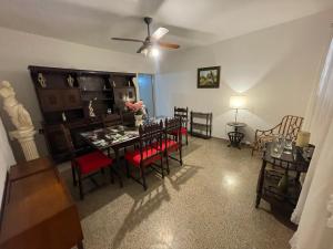 a living room with a dining room table with red chairs at Dulce Hogar in La Banda