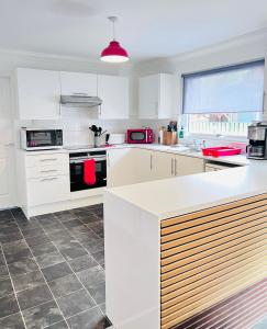 a kitchen with white cabinets and a stove top oven at River house in Birnam