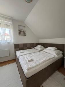 a bedroom with a large bed with white sheets at Barka Vendégház Tisza-tó in Abádszalók