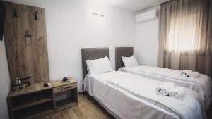 two beds in a hotel room with white sheets at Saint Sava in Ohrid