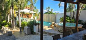 a house with a swimming pool and palm trees at Jobos Beach House - Steps from the beach! in Isabela