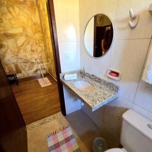 a bathroom with a sink and a mirror at Pousada Cantinho das Fadas in Conceição da Ibitipoca +57 photos