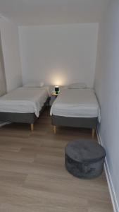 two beds and a ottoman in a room at Maison Agathe in Brussels