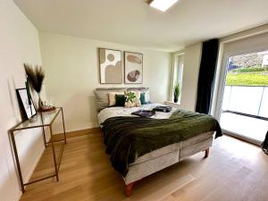 a bedroom with a bed and a large window at Seeblick Wohnung in Wollishofen in Zurich