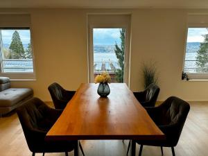a living room with a wooden table and chairs at Seeblick Wohnung in Wollishofen in Zurich