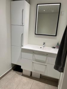 a white bathroom with a sink and a mirror at Lille hus i Sydbyen in Silkeborg