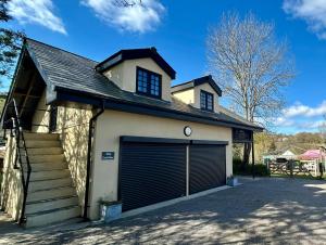 a garage with a garage door and a house at The Coach House in Torpoint