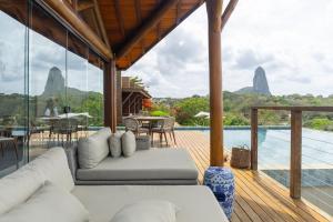 a living room with a white couch on a wooden deck at Colina Pousada SPA in Fernando de Noronha